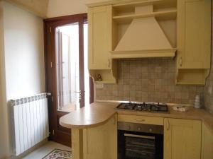 a kitchen with a stove and a sink and a window at B&B Il Granaio in Nociglia