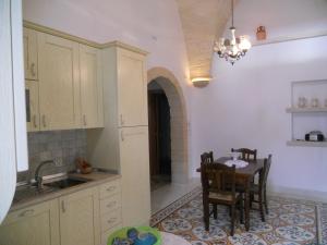 cocina con mesa, sillas y fregadero en B&B Il Granaio, en Nociglia