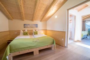 a bedroom with a bed in a room with wooden ceilings at Gasserhof - Chalet B in Frassinetto