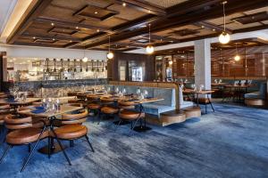 格里菲斯The Gem Hotel的有桌椅和酒吧的餐厅