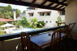 una mesa y sillas en un balcón con piscina en TipTop Hotel, Resto and Delishop, en Panglao