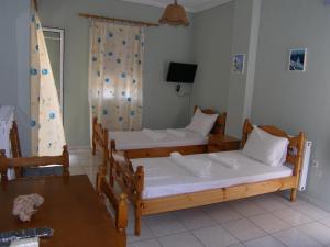 a room with two beds and a table at Efi Apartments (ΕΦΗ) in Myrina