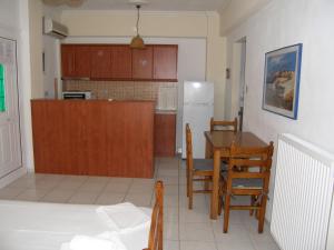 a kitchen and dining room with a table and a refrigerator at Efi Apartments (ΕΦΗ) in Myrina