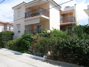 ein großes weißes Gebäude mit Balkon auf einer Straße in der Unterkunft Efi Apartments (ΕΦΗ) in Mirina