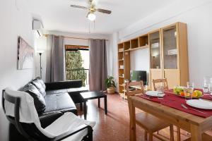 a living room with a couch and a dining room table at MONKÓ CACTUS in Torremolinos
