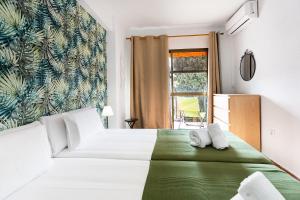 a bedroom with a large white bed and a window at MONKÓ CACTUS in Torremolinos +23 photos