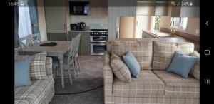 a living room with a couch and a kitchen with a table at Port Haverigg Marina Village in Millom