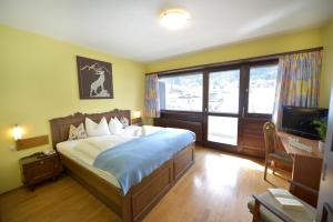 a bedroom with a large bed and a television at Chalet Sonne Vandans in Vandans