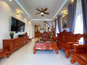 a living room with wooden furniture and a ceiling fan at Đà Lạt Villa 84 Hồ Xuân Hương in Da Lat