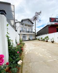 un gran edificio blanco con flores delante en Đà Lạt Villa 84 Hồ Xuân Hương, en Da Lat