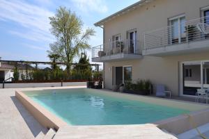 ein Pool vor einem Haus in der Unterkunft aura AR holiday-home in Peschiera del Garda