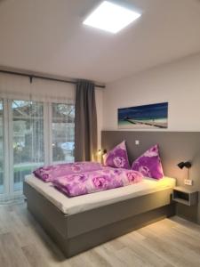 1 dormitorio con cama rosa y ventana en Pension Seeufer Norddeich, en Norddeich