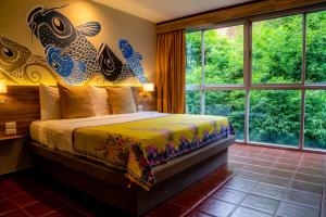 a bedroom with a bed with a large window at Sino House Phuket Hotel - SHA Plus in Phuket
