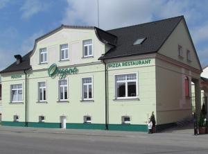 a large white building on the side of a street at Penzion Oregano Třeboň in Třeboň