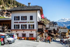 a building on a street in a mountain town at Hotel de Moiry Supérieur in Grimentz