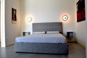 a bedroom with a large bed with a large headboard at aura AR holiday-home in Peschiera del Garda