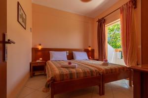 a bedroom with a large bed with a window at Villa Sophia Apartments by CorfuEscapes in Agios Gordios