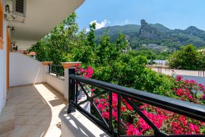 a balcony with pink flowers and mountains in the background at Villa Sophia Apartments by CorfuEscapes in Agios Gordios