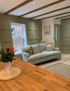 a living room with a couch and a table at Ferry Lane Cottage in Kings Lynn