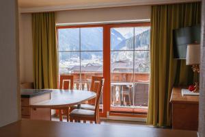 Zimmer mit einem Tisch und einem großen Fenster in der Unterkunft Landhaus Severin in Neustift im Stubaital