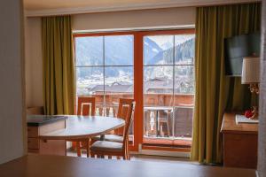 a room with a table and a large window at Landhaus Severin in Neustift im Stubaital