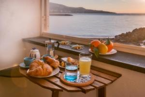 a breakfast table with croissants and orange juice and a window at La Casa del Verricello - Sea view house in Meta +17 photos