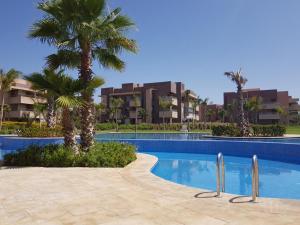 una piscina con palmeras y edificios en Prestigia 16, en Marrakech