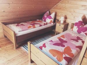 - une chambre avec 2 lits et un mur en bois dans l'établissement Bauernhof Oberfriessnig, à Radenthein