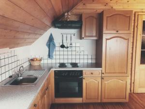 a kitchen with wooden cabinets and a stove top oven at Bauernhof Oberfriessnig in Radenthein