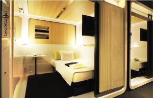 a hotel room with a bed and a mirror at First Cabin Kansai Airport in Izumi-Sano