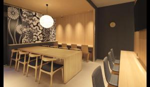 a dining room with a wooden table and chairs at First Cabin Kansai Airport in Izumi-Sano