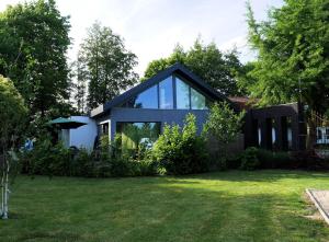 uma casa com janelas de vidro e um quintal em Git Émoi em Estaimpuis