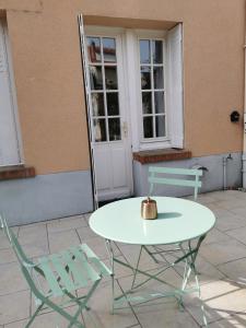 uma mesa e duas cadeiras sentadas fora de um edifício em Les Rauches - Quai Loire - Chambre Jungle em Châteauneuf-sur-Loire