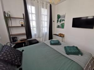 um quarto com uma cama com duas almofadas verdes em Les Rauches - Quai Loire - Chambre Jungle em Châteauneuf-sur-Loire