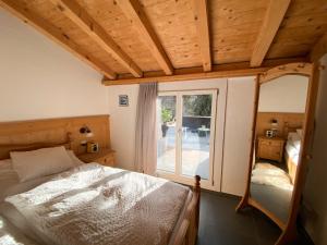 1 dormitorio con cama y ventana grande en Mira Piz Signina - Ferienwohnung für max. 4 Personen, en Laax