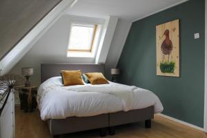 1 dormitorio con 1 cama con una foto de pájaro en la pared en Grytmanshoeve, Vakantiehuis met glamping en Niawier