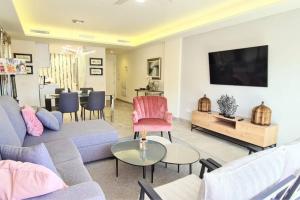 a living room with a couch and a tv at LUJOSO APARTAMENTO NUEVO PLAYA CENTRO in Estepona