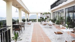 a patio with tables and chairs on a building at ĐTT Galaxy Tam Chúc in Ðục Khê
