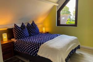 um quarto com uma cama com lençóis azuis e uma janela em Family vacation in a spacious and comfortable holiday house em Bruinisse