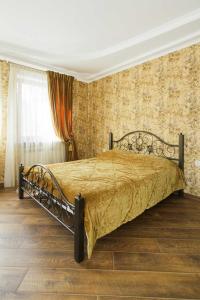 a bedroom with a bed with a gold bedspread at APARTMENT IN DERIBASOVSKAY STREET 20 in Odesa