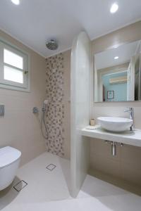 ein Badezimmer mit einem Waschbecken, einem WC und einem Spiegel in der Unterkunft ALK Hotel in Kamarai