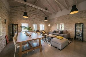 a living room with a wooden table and a brick wall at Paxos StoneHouse in Gaios