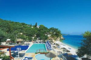a resort with a swimming pool and beach with umbrellas at Paxos StoneHouse in Gaios