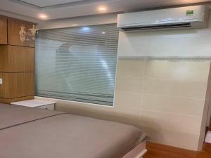 1 dormitorio con 1 cama y ventana con ventilador en Binh An Hotel, en Ho Chi Minh