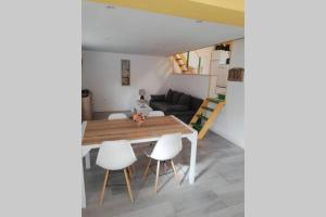 uma sala de estar com uma mesa e cadeiras brancas em COPACABANA em La Fère