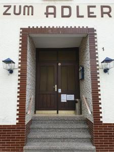 eine Eingangstür eines Gebäudes mit einer Treppe davor in der Unterkunft Pension Zum Adler in Limbach