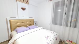 sypialnia z łóżkiem z fioletowymi poduszkami i oknem w obiekcie Sunny Seaside Escape in Aguadulce w mieście Aguadulce