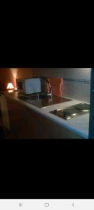 a kitchen counter with a sink and a stove at Guest House Pacifica in Quarteira
