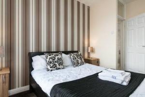 um quarto com uma cama com almofadas em GARDNER HOLIDAYS HOUSE em Manchester