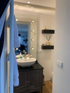 uma casa de banho com um lavatório e um espelho em Place To Be em Naarden
